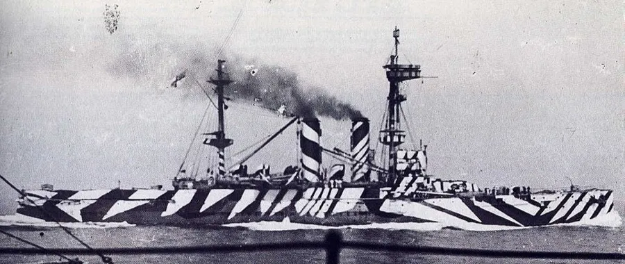 HMS London as a minelayer in May 1918, painted in dazzle camouflage of black, white, gray, blue, and cream.