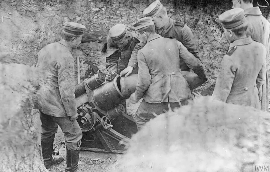 Photograph of German soldiers loading a 25 cm Minenwerfer, early short-barrel model, World War I .