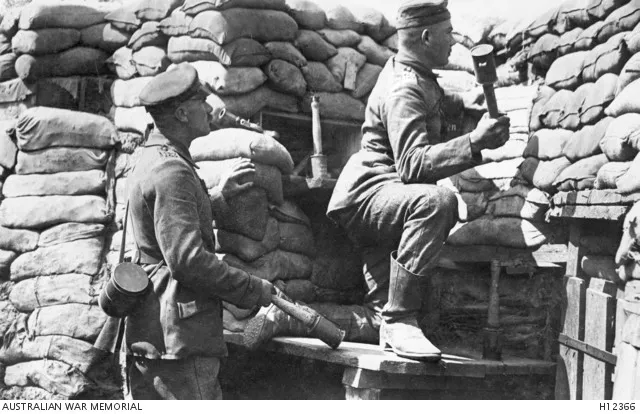 Two German soldiers in a sandbagged trench holding stick grenades (Stielhandgranaten)